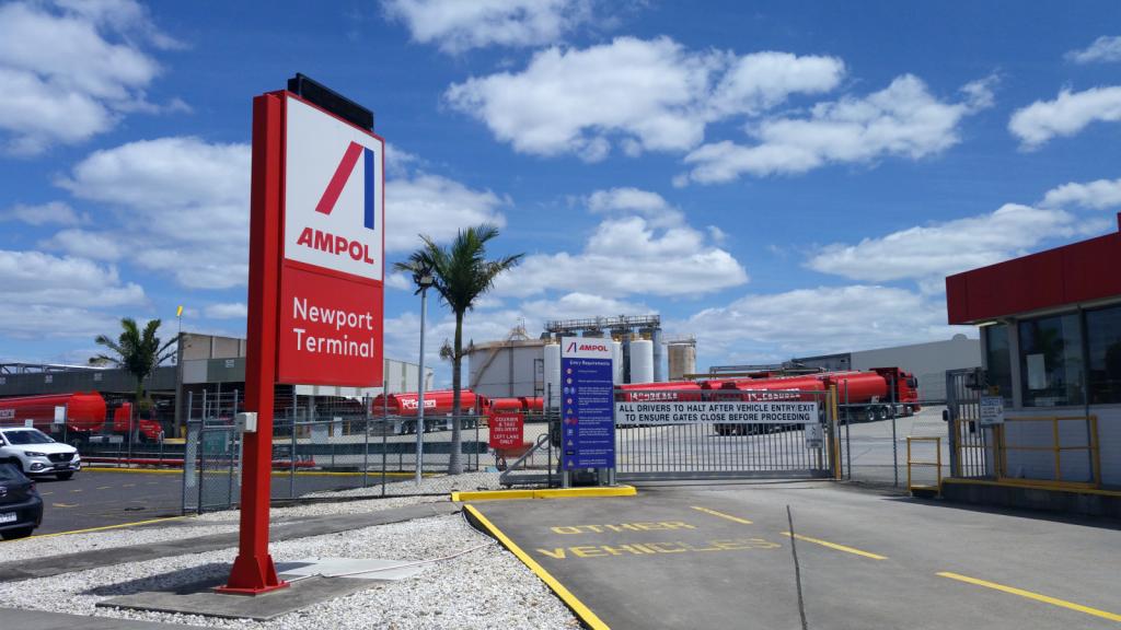 A sign saying "Ampol Newport Terminal" in front of a vehicular entry gate and said oil terminal.